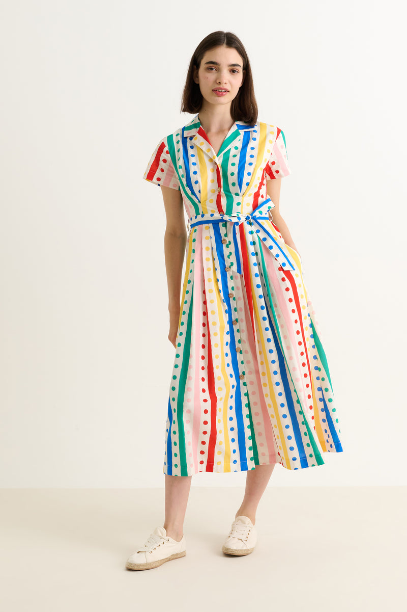 Woman wearing a colorful polka dot dress on a white background